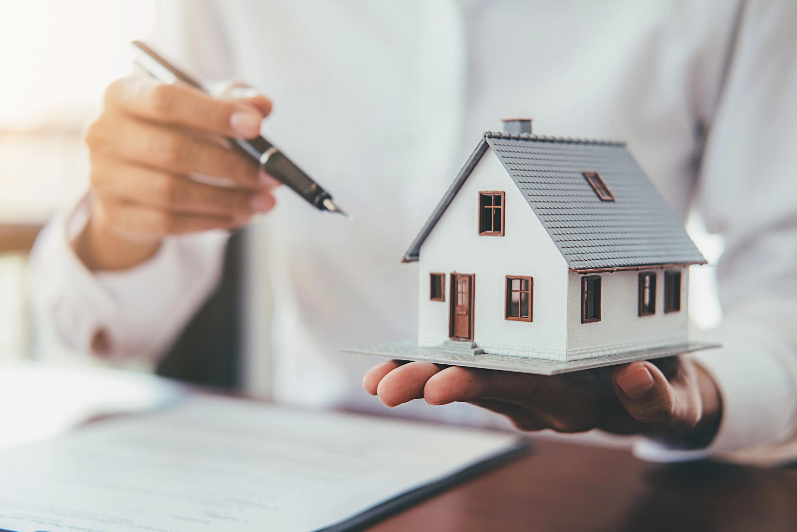 House model with real estate agent and customer discussing for contract to buy house House model with real estate agent and customer discussing for contract to buy house
